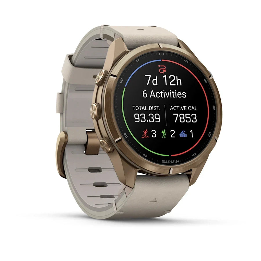A Garmin smartwatch with a round bronze-brown case and a light beige silicone strap, shown on a clean white background. The watch face is active with various fitness metrics displayed.
