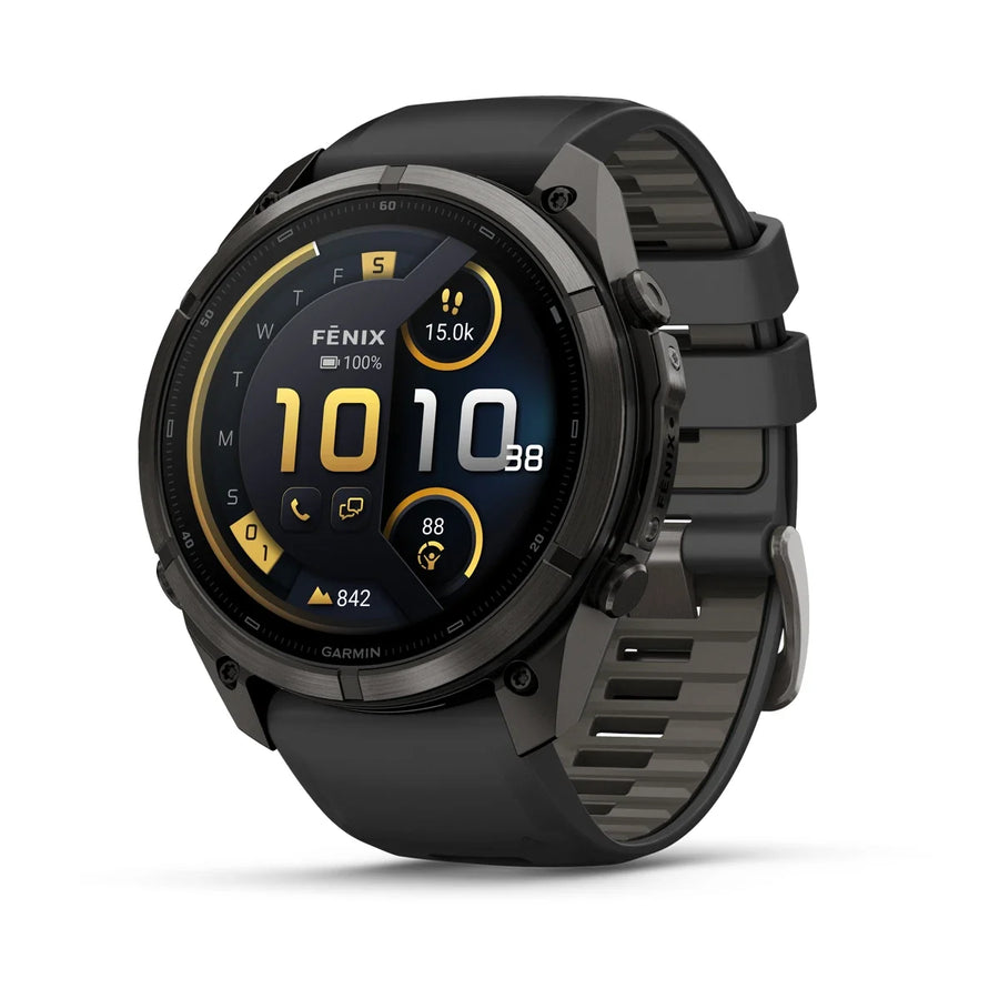 A Garmin Fenix smartwatch with a round black and dark gray case and a textured black strap, shown at a three-quarter angle on a white background. The watch face displays a dark watch UI with yellow accents.